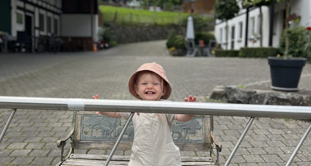 Kleinkind steht am Hoftor